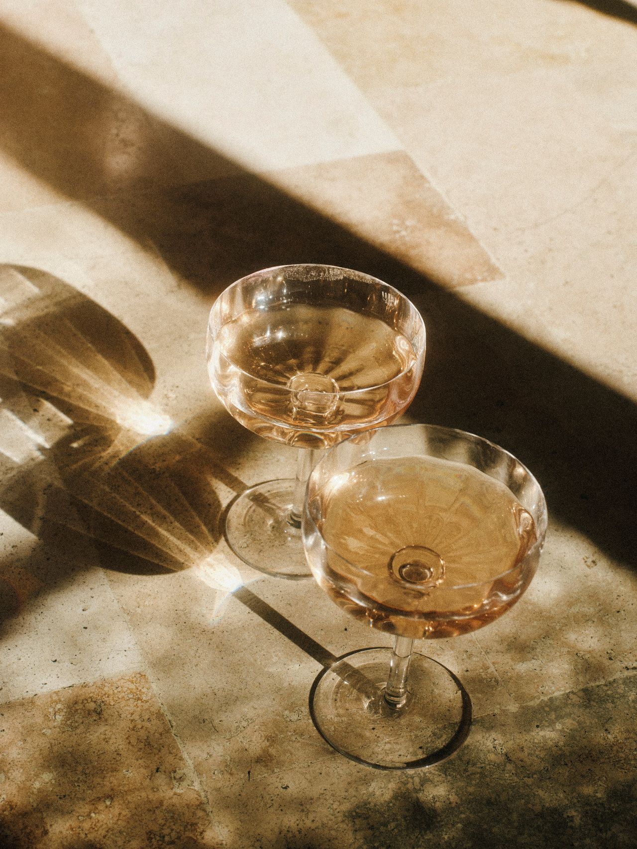Two coupes of champagne in warm sunlight